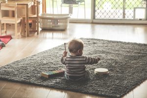 young child playing on a xylophone and drum