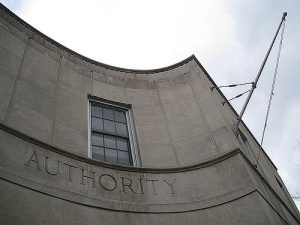 Curved cement building with AUTHORITY carved beneath a window