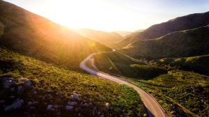 Image of a country road between rolling hills.