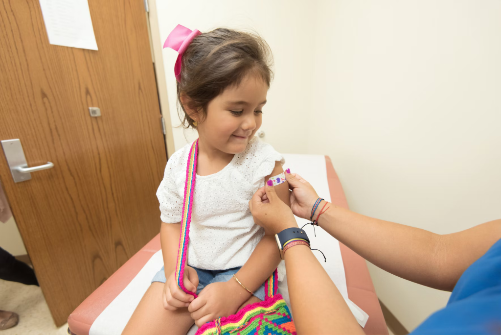 Girl getting a band-aid after immunization.