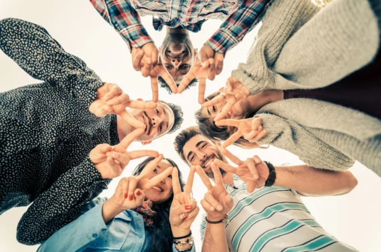 Multiracial group of people in circle making a star shape with hands gesture - Friends looking down with v-shapes finger position