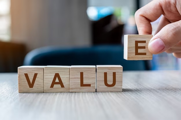 Person creating the word &quot;value&quot; by placing the wooden blocks with letters on the table