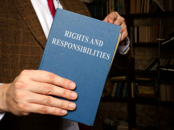 Manager in suit holds rights and responsibilities book.