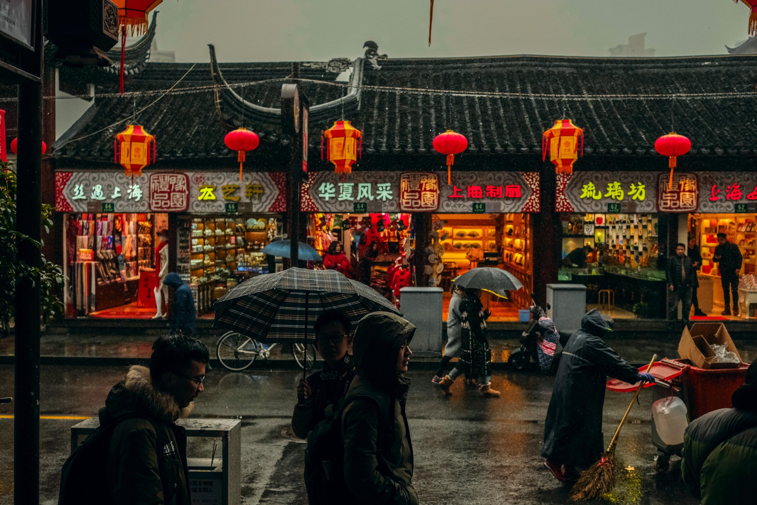 People walking by Chinese stores in a rainy weather