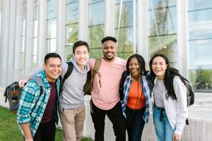 Group of high school students standing in a row with their arms around each other.