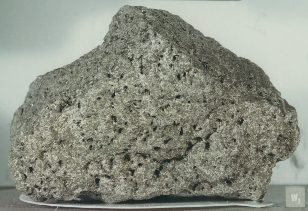 Photograph of a Lunar Rock. A sample of basaltic rock from the Lunar surface is shown, with the many holes left by gas bubbles giving the rock the appearance of a sponge.