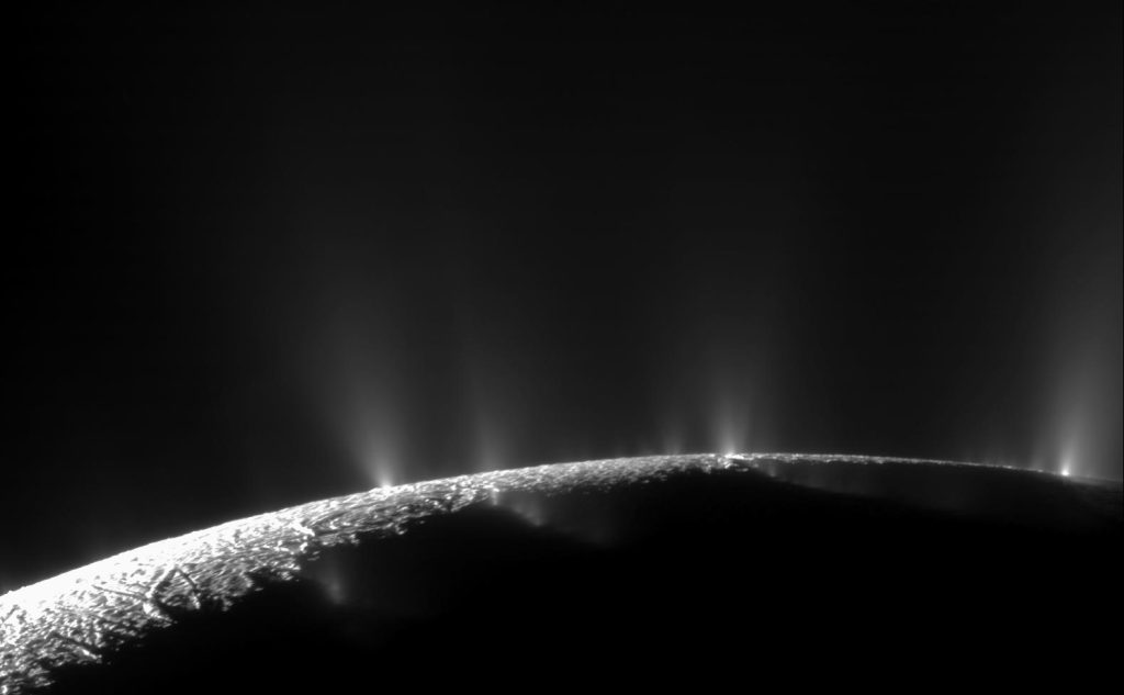 An image of the surface of Enceladus, from which a number of water geysers stream.