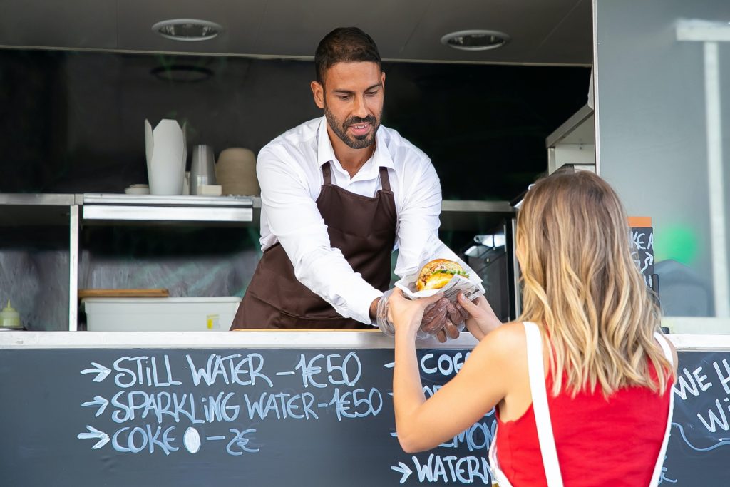 Owner of a food truck serving a customer