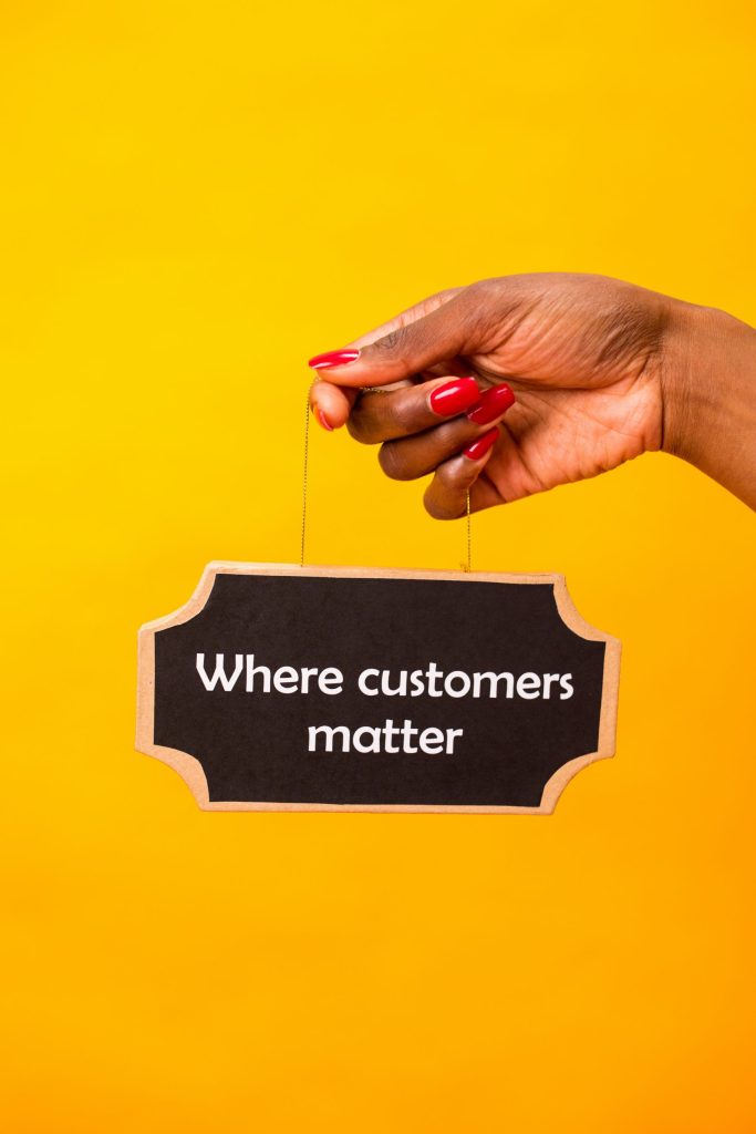 A person holding a sign saying "Where customers matter"