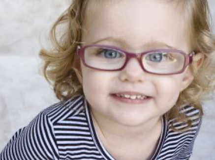 Smiling little girl wearing pink glasses.