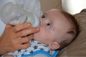 A baby being held and bottle fed.