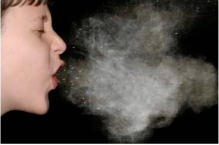 A child appears to be coughing or sneezing, and a cloud is coming out of their mouth.