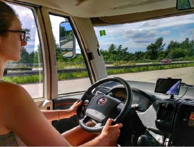 A woman sitting in the driver's seat of a vehicle.