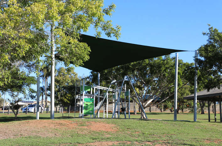 An outdoor playground under a tent top.