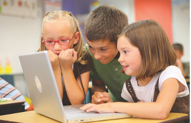 Three children crowd around a laptop and look at something on the screen.