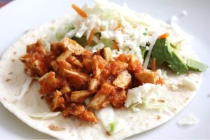 Marinated tofu on a tortilla with other ingredients.