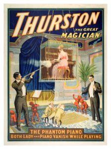 A colourful poster advertising a magic show. At the top of the poster the words “Thurston the Great Magician” are printed in large font. At the bottom of the poster in block letters are the words: The Phantom Piano. Both Lady and Piano Vanish While Playing. The central part of the poster shows a woman playing a piano in a large cage suspended above the floor. She wears a pink dress and has her back to the viewer. On the ground below her are two well dressed white gentlemen, the one on the left holds a rifle, the one on the right stands with his arms spread apart in front of him. The word VANISH is on the ground between the men, it appears to be written on a carpet or piece of fabric. There are three miniature bald men in yellow coats examining it on the left side, and two little red devil-type characters who seem excited by the proceedings on the right side. There are two more little devils near the man with the rifle. The room this is taking place in is elegantly decorated–plush blue curtain, an ornate carpet, and an elegant potted palm tree