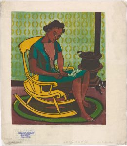 A colourful illustration of a black woman sitting in a yellow rocking chair, knitting. The woman is wearing a short-sleeved green dress and is looking intently at her work. Under the chair and her feet, a circular rug sits on the reddish-brown floor. A wood stove is placed against the green wall in the background, the wall has yellow half-circle designs.