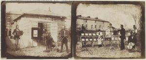 Two side-by-side sepia-tone photographic images of the same size. the left image is of four white men dressed in mid-19th-century suits. they are located in what appears to be a backyard, in front of a white shed or greenhouse which is covered in small rectangular windows. Two men, one on the far left, and the other on the far right, have a variety of camera equipment on tripods. the cameras are large boxes, roughly about 30cm in height. One of the men is sitting in a chair, his right arm resting on a table with a top hat placed just beside his elbow. The fourth man is standing in the doorway of the shed, looking at the man in the chair. Behind the shed, we can see three brick houses at varying distances. The right image shows five white men, all wearing similar suits to the left image. Rows of white photographic plates on racks span the central area of the image. Centre left, a man in an apron tends to one of these plates. On the far left, a man in a top hat is standing behind these plates. the other three men are clustered towards the right. The leftmost of these three is operating a box camera on a tripod. Just to his right, a man kneels interacting with what appears to be a circular apparatus divided into quarters. Behind them is a man standing in profile wearing a top hat.