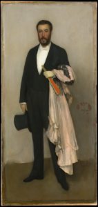 An oil painting of a man standing in front of a plain white background, standing on a dark brown floor. The man is dressed in a suit and is holding a top hat in his right hand, which is hanging at his side. His left arm is bent at the elbow, and draped over this arm is a pink dress. He is holding a closed red paper fan in his left hand.