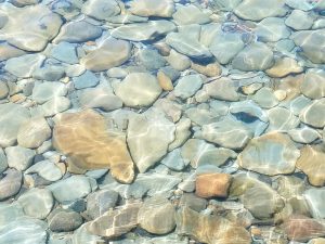 Un plancher de roches vu à travers une eau limpide