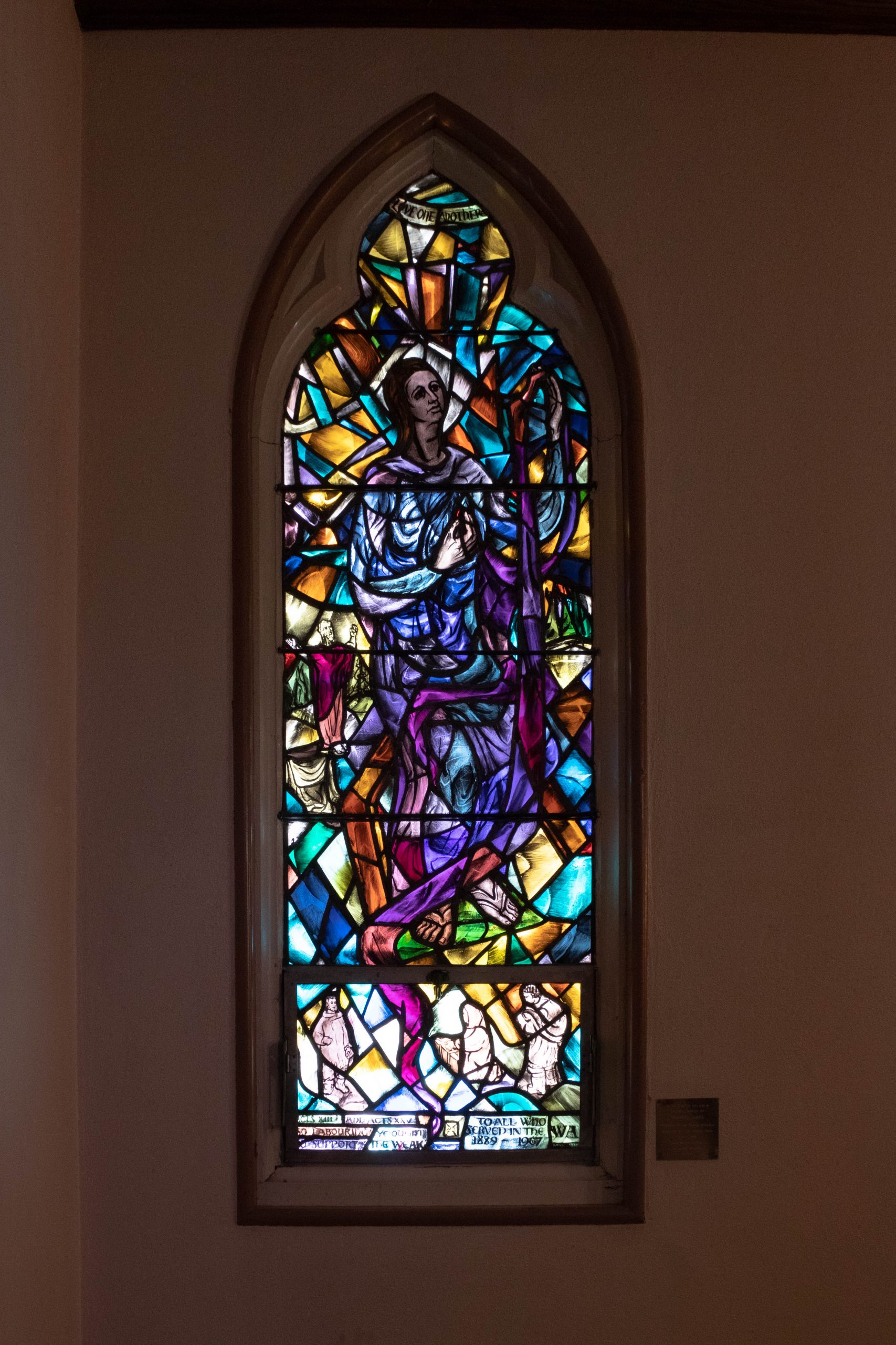 Stained glass window with woman and abstract panels. 