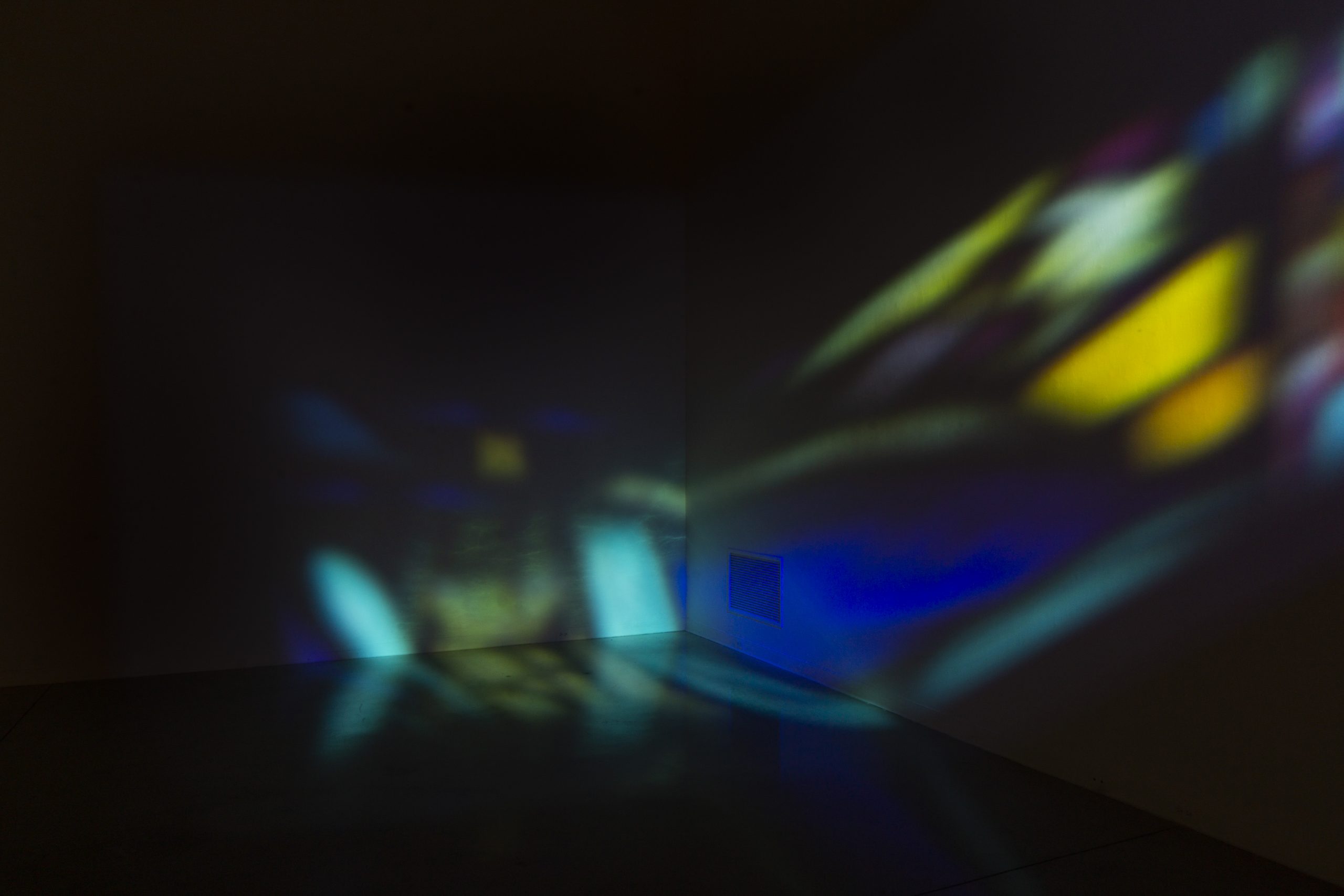 A dimmed art gallery wall with reflective lights like stained glass.