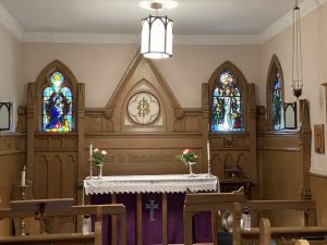 Chapel showing three stained glass windows and altar.