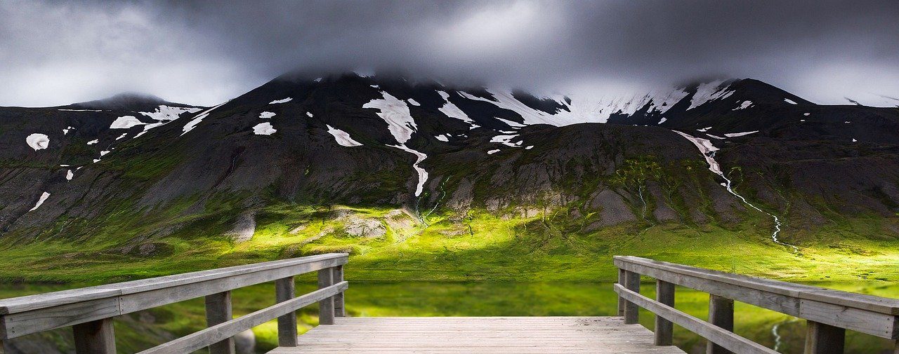Bridge with field and mountain in the background