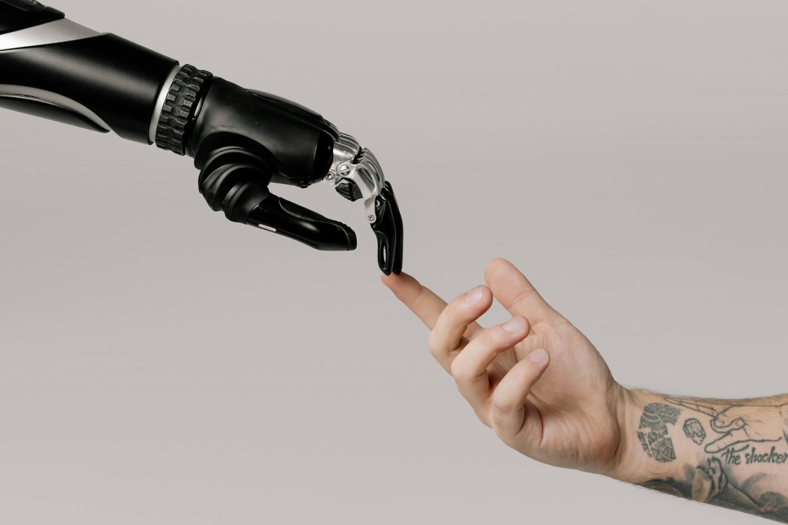 robot hand and a human hand touch using their index fingers