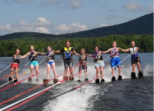 A family of 8 water skiing behind a boat