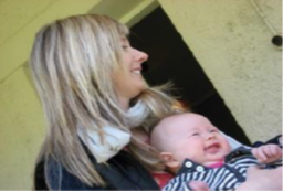 Woman smiling while holding a smiling baby