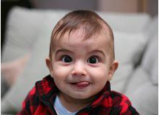 Young boy sticking his tongue out while looking at the camera