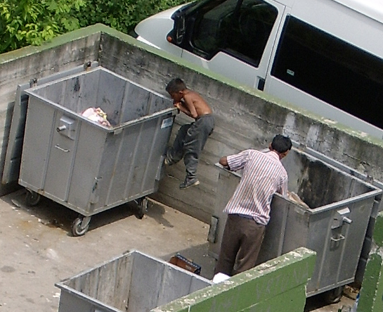 2 boys looking through dumpsters