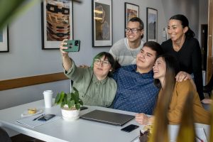 photo depicts a group of Indigenous adults taking a selfie in a restaurant