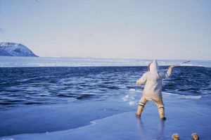 Inuit person fishing in icy waters