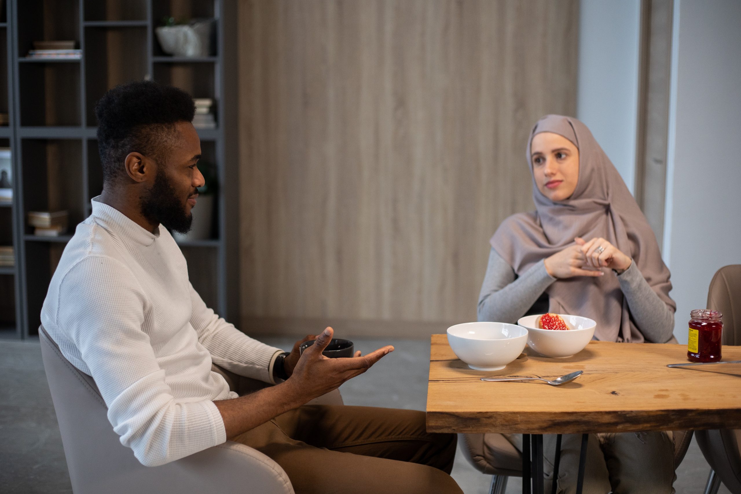 Delighted diverse couple having breakfast at table