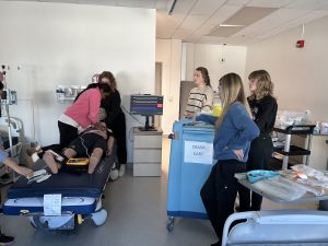 Students practicing CPR on a dummy in class