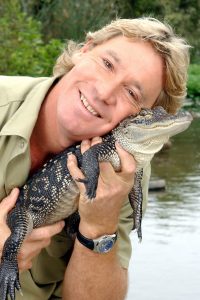 Image of Steve Irwin, snuggling a baby crocodile.