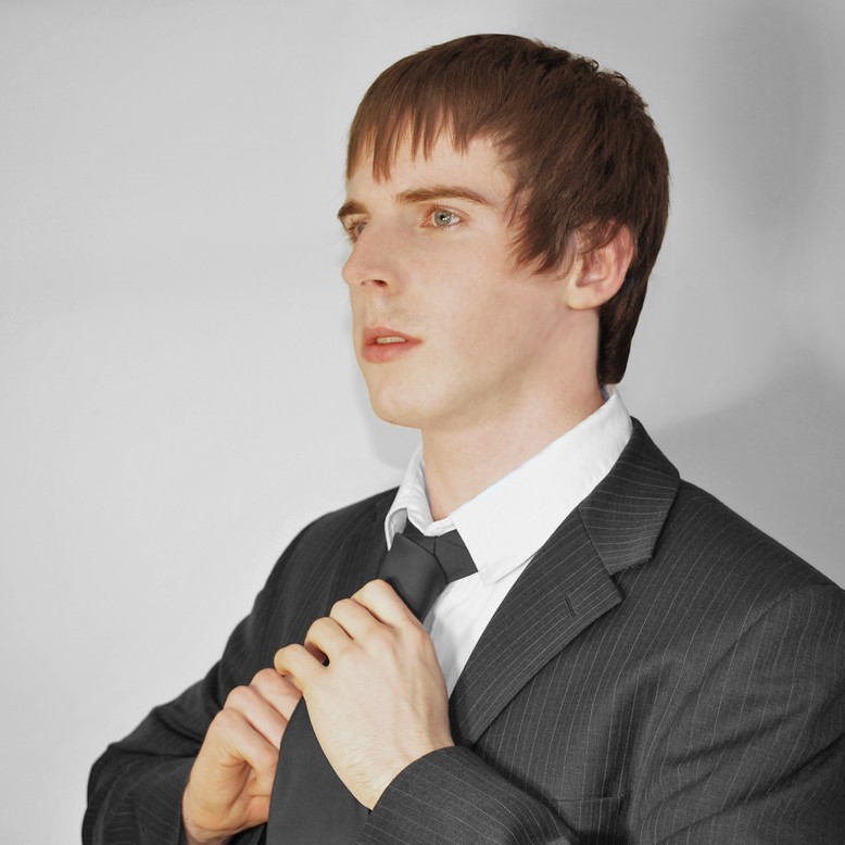 adolescent male fixing a neck tie