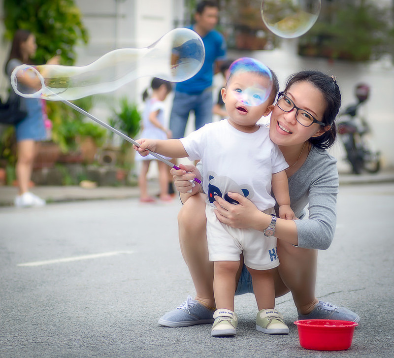 mother and young child playing with bubbles