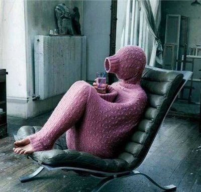 person wearing a full knitted sweater that covers their head