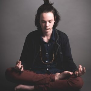 photo of a person sitting corss-legged with eyes closed