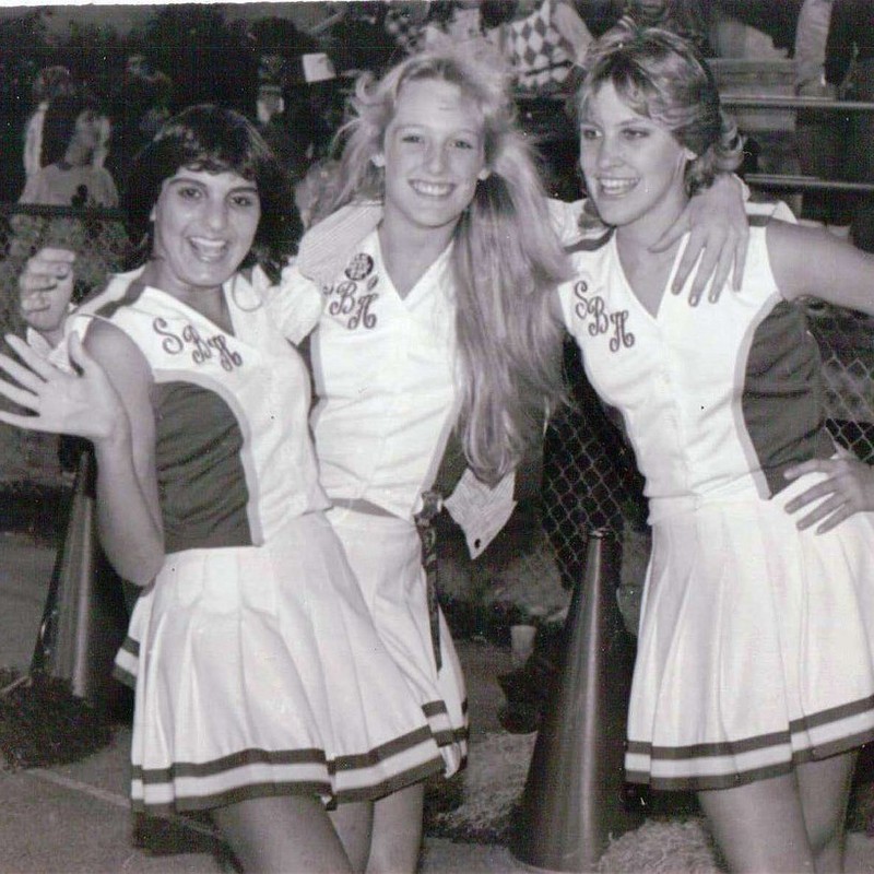 black and white photo of three females dressed in the same uniform smiling