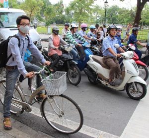 photo of people stopped on bikes and scooters on a street