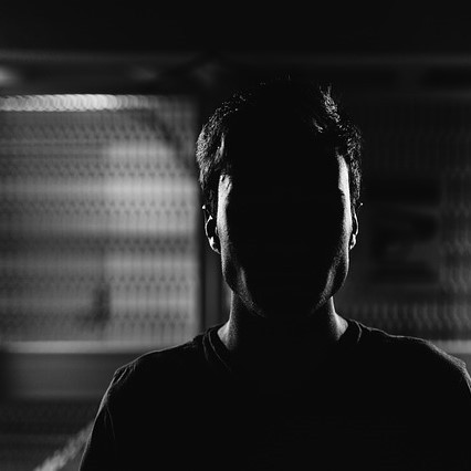 black and white photo of a man with shadows covering his face