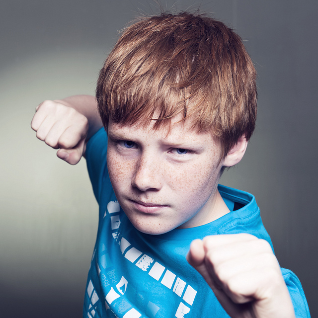 photo of a adolescent boy making fists at the camera