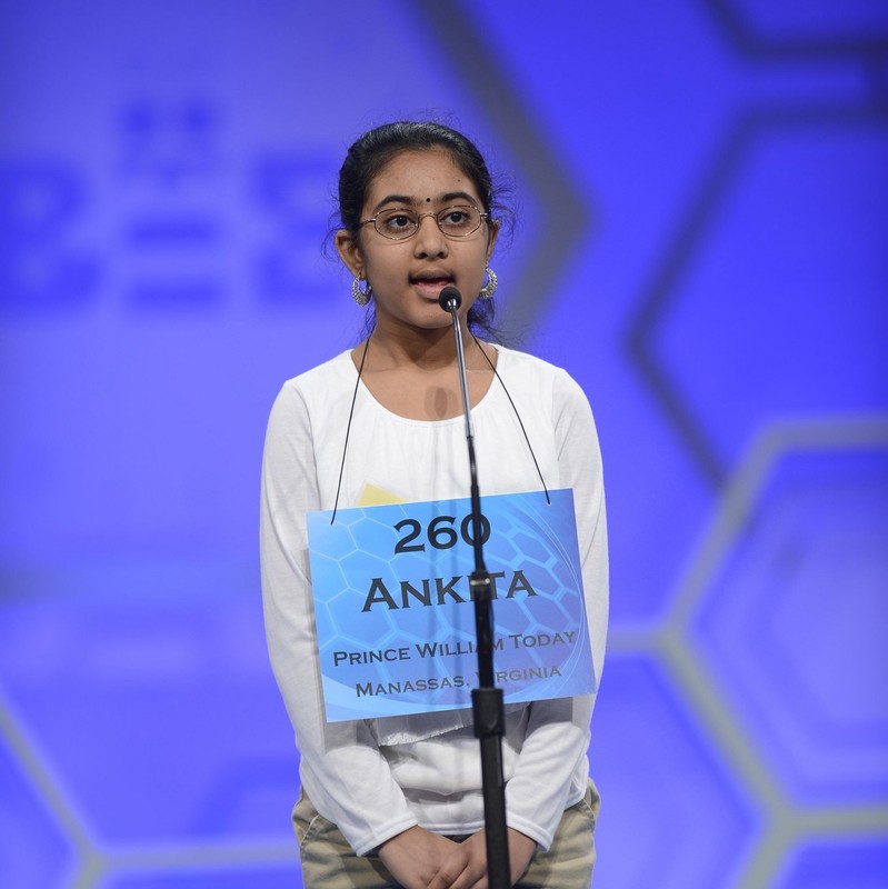 photo of a girl standing on stage in front o fa microphone wearing a name tag