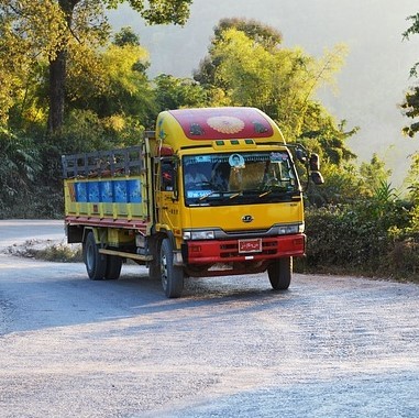 photo of a truck driving on a winded road