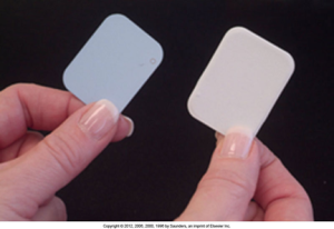 Two hands holding a traditional #2 intraoral dental film next to a similarly sized digital imaging sensor.